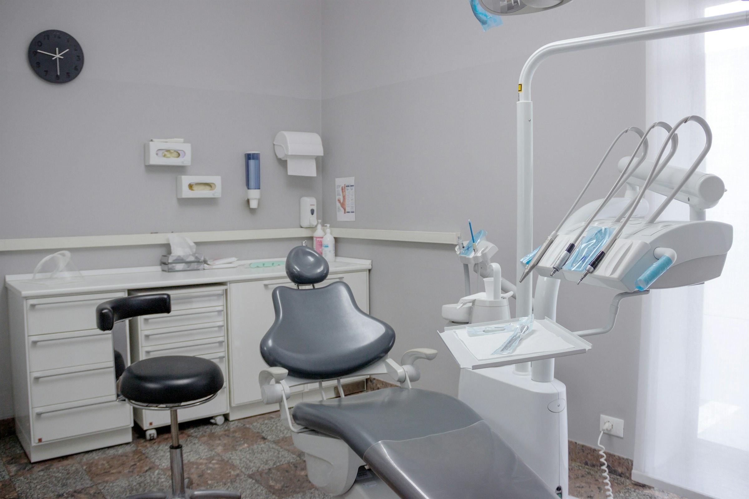 Dental operatory with a patient chair, overhead light and instrument tray