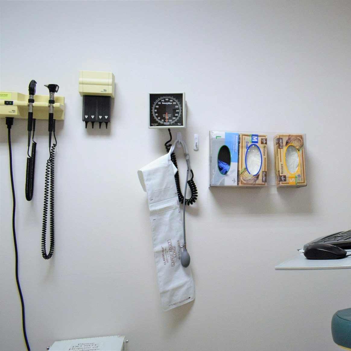 Medical exam room with a blood pressure cuff, diagnostic tools and glove dispensers